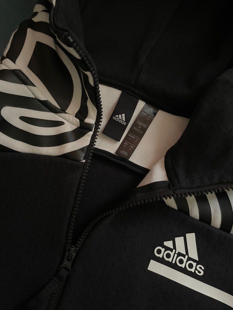 Adidas Full Zip Hoodie (Category: Hoodies) located in Manila. Submitted by lrj_stuff (Listing ID 1405661333, Image 2). Description: - Adidas full zip hoodie - Unique black and white patterned hood - Black color with textured fabric - Full zip closure - Two side pockets with zippers - Adidas logo on chest - Size tag visible in photos.
