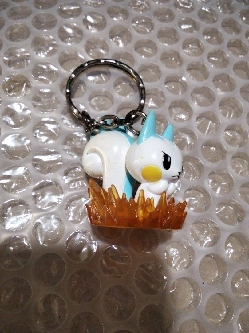 Anime Character Keychain (Category: Character Goods) located in Santa Rosa. Submitted by animemerchcollection (Listing ID 1405560350, Image 2). Description: - Adorable anime character keychain - Features a white body with blue accents - Includes a yellow cheek detail - Character design: Sitting in orange flames - Comes with a durable silver keyring.