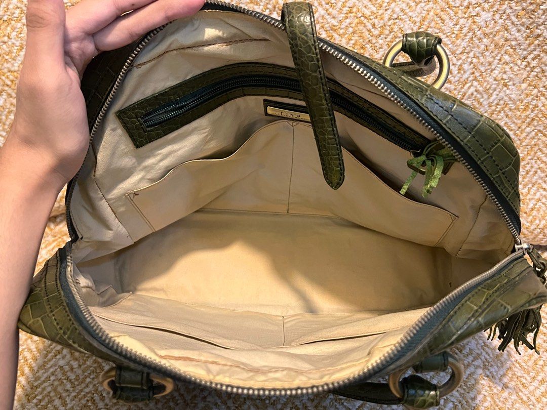 Fino Leatherware Green Handbag (Category: Luxury Bags & Wallets) located in Taguig. Submitted by lyeche3 (Listing ID 1405639275, Image 3). Description: Lightly used. Great condition although theres a bit of a slight discoloration in the inside. Height: A bit over 10 inches Width: Around 13 inches - Fino Leatherware green handbag - Crocodile-embossed design - Two front pockets - Top handle.