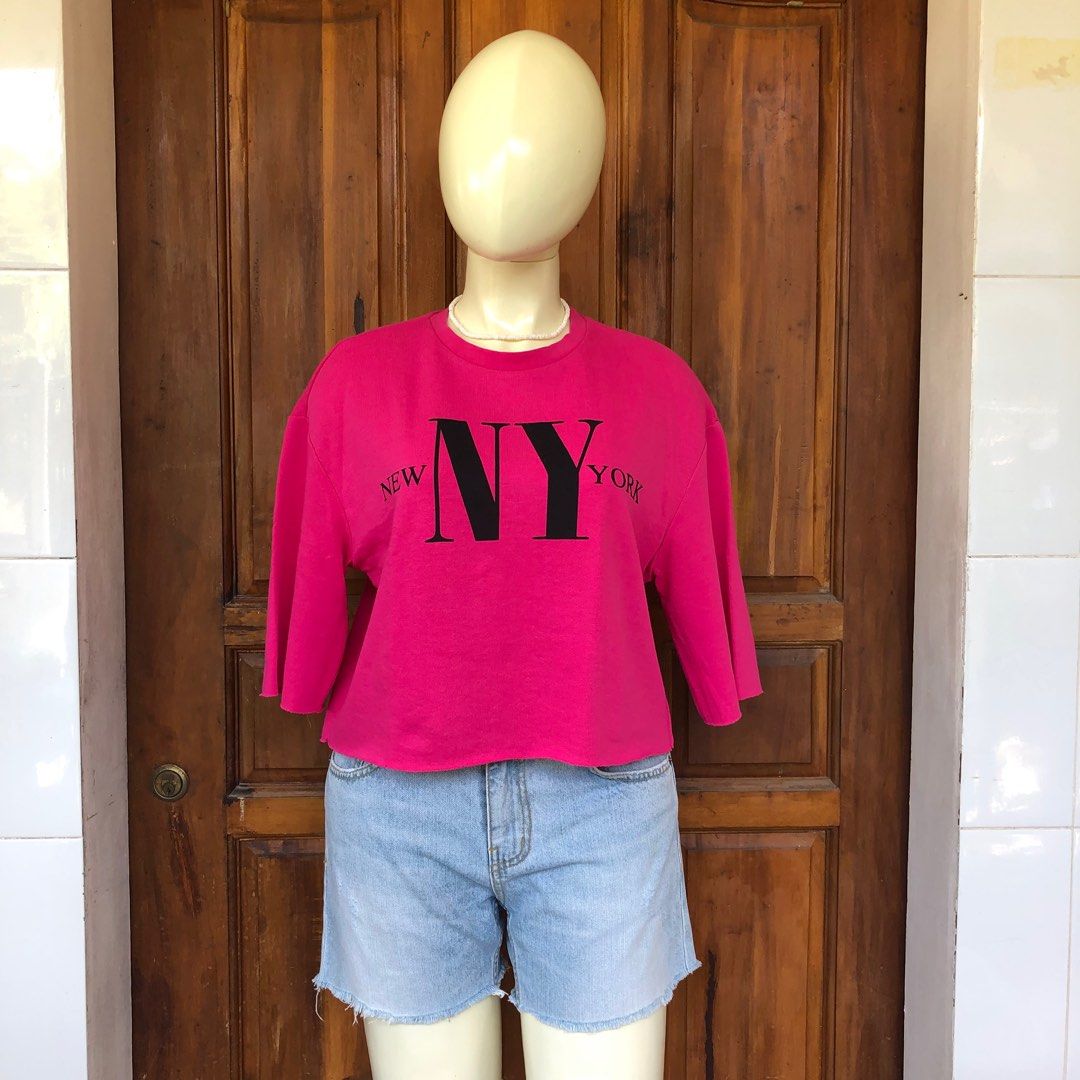 H&M Divided NY top (Category: Blouses) located in Naga. Submitted by ajmaq (Listing ID 1405661294, Image 1). Description: - H&M Divided sweatshirt - Bright pink color - "NY" graphic - Size: Small on tag but it can fit up to large - Cropped, raw hem - 3/4 sleeves - Crew neck - Perfect for a casual look.