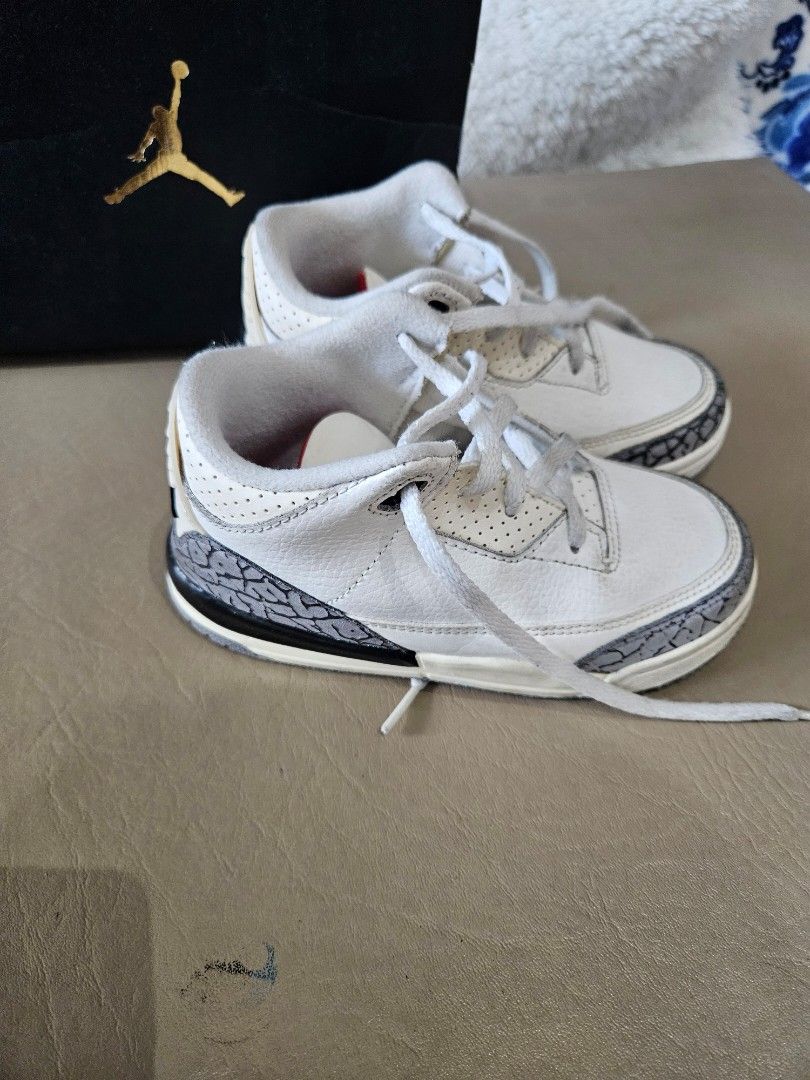 Air Jordan 3 Retro TD White Cement (Category: Babies & Kids Fashion) located in Manila. Submitted by inlababoqueen (Listing ID 1405795039, Image 2). Description: - Air Jordan 3 Retro TD sneakers - Color: White with grey and black accents - Features the iconic elephant print - Red detailing on the inside - Size 10C RFS:Outgrown/Decluttering.
