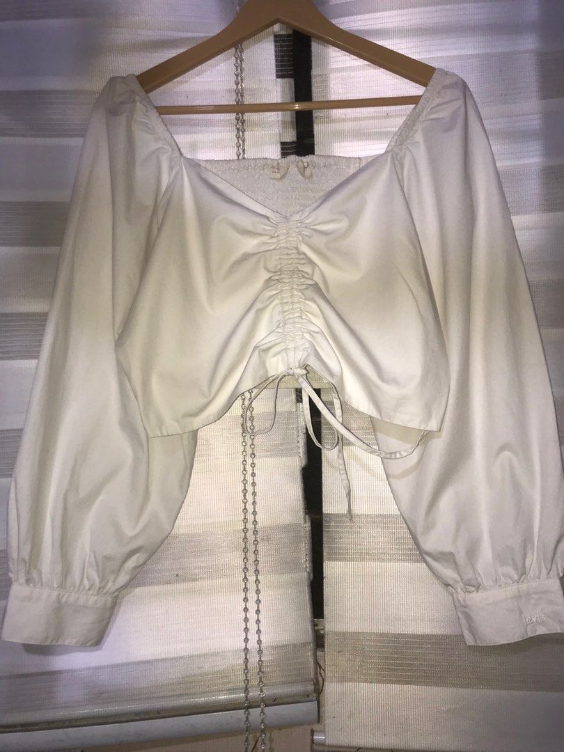 Levi's White Puff Sleeves Cropped Top (Category: Sleeveless) located in Makati City. Submitted by closet.declutterph (Listing ID 1405751860, Image 1). Description: - Levi's cropped top - White color - Size: L - Features a square neckline - Long sleeves - Ruched detail in the front - Smock at the back.