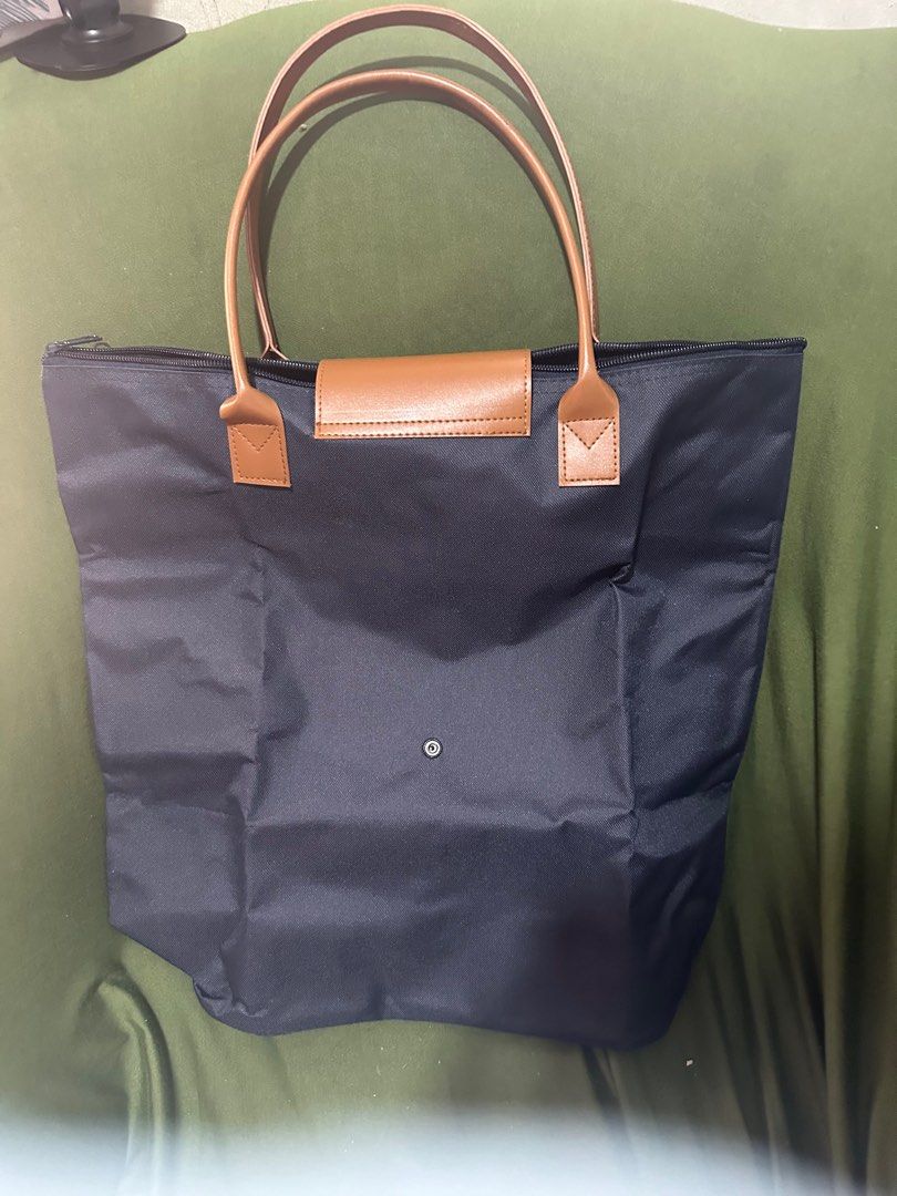 Navy Blue Tote Bag with Brown Handle (Category: Tote Bags) located in Taguig. Submitted by sshyn_08 (Listing ID 1405745439, Image 2). Description: - Navy blue tote bag - Brown handles - Flap closure - Zipper closure at the top - Spacious interior - Made of durable material - Versatile for everyday use.