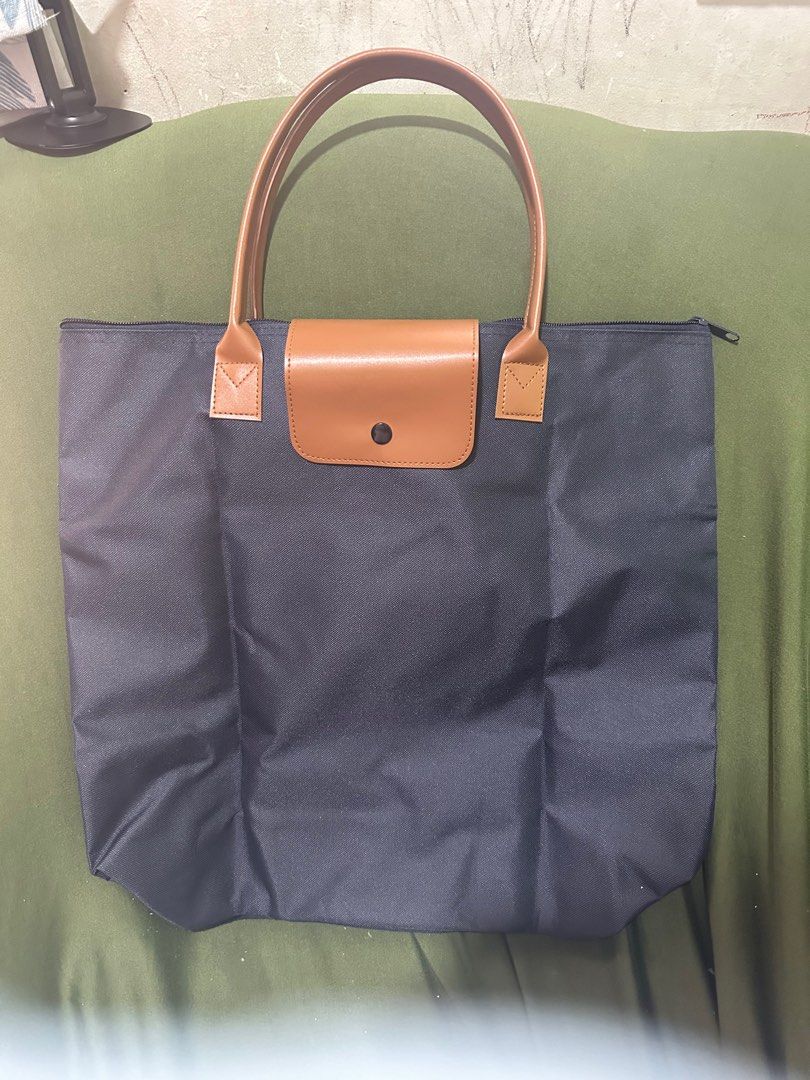Navy Blue Tote Bag with Brown Handle (Category: Tote Bags) located in Taguig. Submitted by sshyn_08 (Listing ID 1405745439, Image 1). Description: - Navy blue tote bag - Brown handles - Flap closure - Zipper closure at the top - Spacious interior - Made of durable material - Versatile for everyday use.