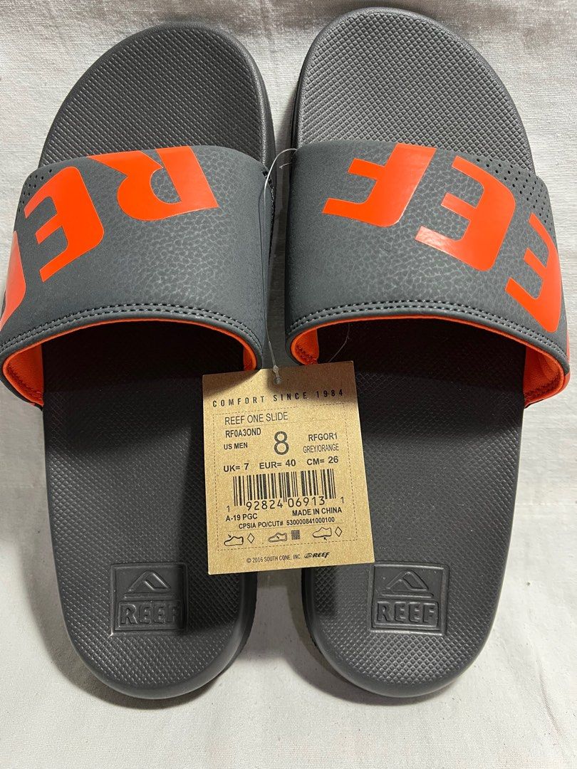 Reef One Slide Sandals - Grey/Orange (Category: Slippers & Slides) located in Antipolo. Submitted by gettinghooked (Listing ID 1405726576, Image 1). Description: - Reef One Slide sandals - Color: Grey with orange accents - Features Reef logo - Size: US Men's 8, UK 7, EUR 40, CM 26 - New with tags.