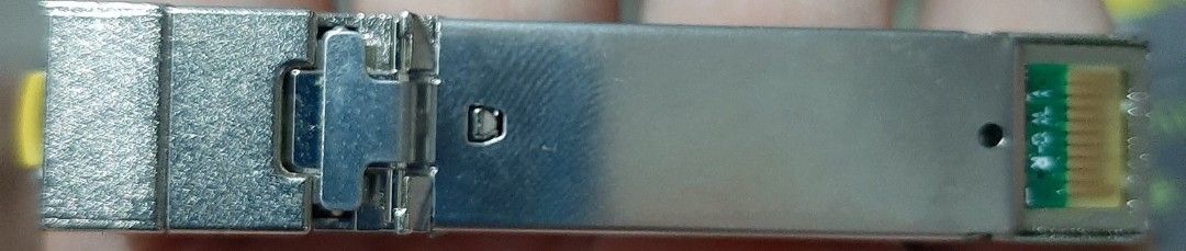 RJ45 SFP Transceiver Module (Category: Networking) located in Quezon City. Submitted by refugeemack (Listing ID 1405859951, Image 2). Description: - Cisco SFP transceiver module (RJ45) - P1500.00 each - Metal casing for durability - Connector with a visible yellow component - Includes a small circuit board - Designed for network connectivity - Ensures reliable network performance.