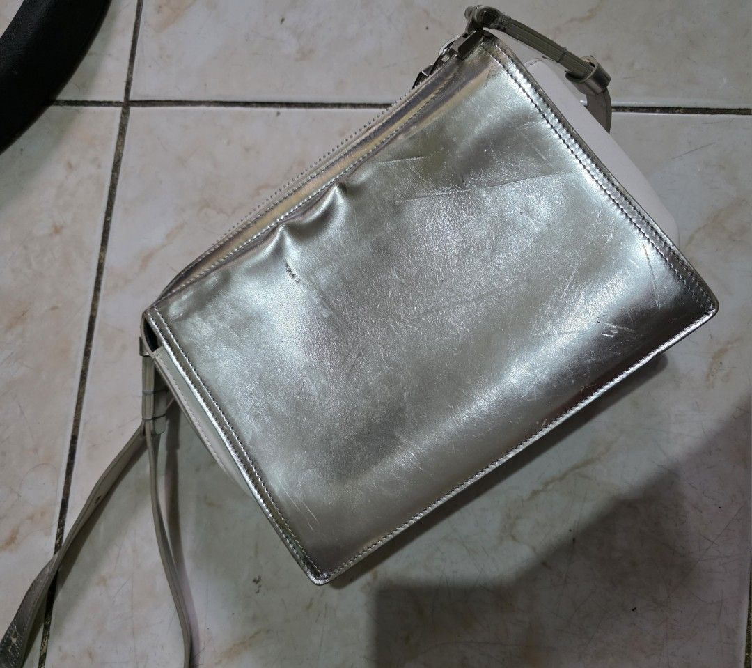 Roger Vivier Paris Silver Shoulder Bag (Category: Luxury Bags & Wallets) located in Quezon City. Submitted by phoejay (Listing ID 1405726676, Image 3). Description: - Roger Vivier Paris shoulder bag - Silver metallic finish - White leather base - Silver-tone shoulder strap - Rectangular clasp - Black leather interior - Roger Vivier Paris logo - Zipper closure.