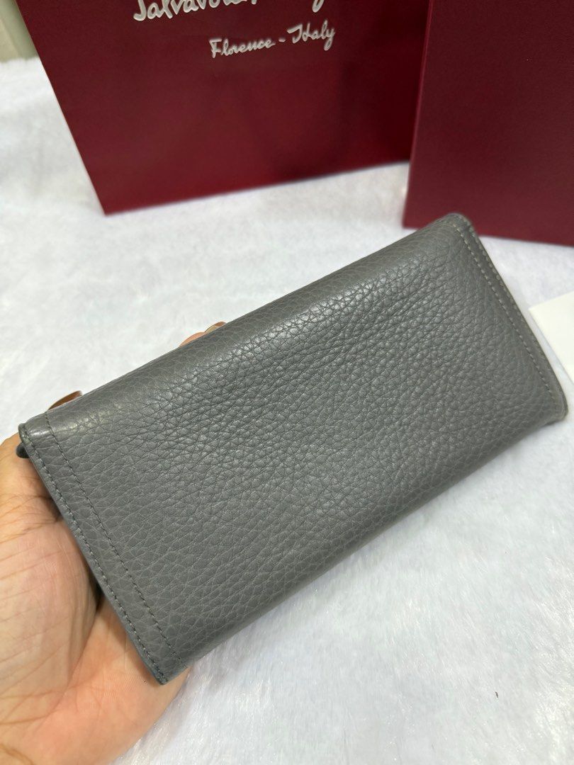 Salvatore Ferragamo Grey Leather Wallet (Category: Luxury Bags & Wallets) located in Taytay. Submitted by allluxbymaureenreyes7 (Listing ID 1405749292, Image 3). Description: - Authentic Salvatore Ferragamo wallet - Grey leather exterior - Gold-tone clasp and hardware - Includes original box, shopping bag, and authenticity card - Multiple card slots and zippered compartment inside - Made in Italy.