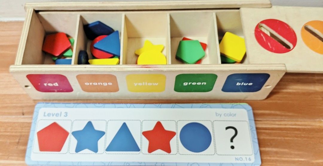Wooden Shape and Color Sorter (Category: Educational & Learning Toys) located in Tanza. Submitted by c.avel (Listing ID 1405825645, Image 2). Description: - Wooden shape and color sorter - Includes box with colored slots and matching shapes - Shapes: Red, Orange, Yellow, Green, Blue - Comes with cards for different levels of play - Box features a sliding lid for easy shape access UNCOUNTED.