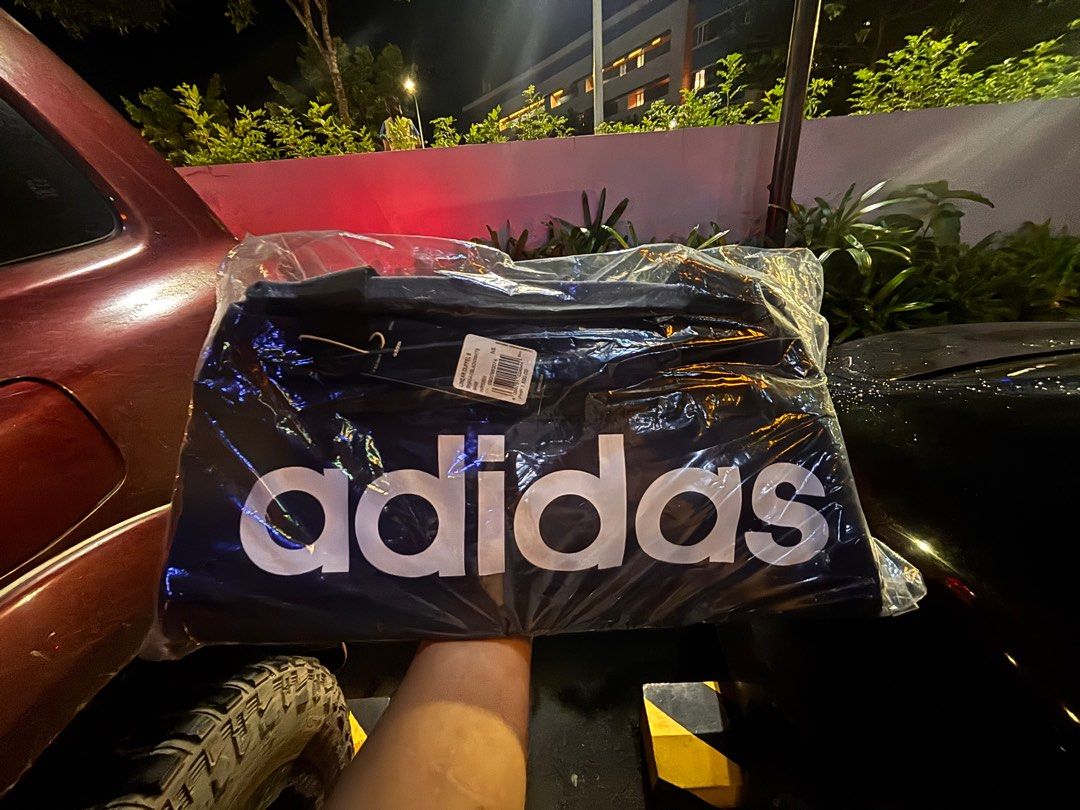 Adidas Linear Duffel S - Black/White (Category: Sling Bags) located in Pila. Submitted by eliphalez (Listing ID 1406022126, Image 2). Description: Adidas Linear Duffel S in blue and black.The bag is new and still in its original packaging. It has a large Adidas logo on the front. The price tag shows a price of PHP 1,500. Size:25L Brandnew Colorway: Pink/Blue/Green.