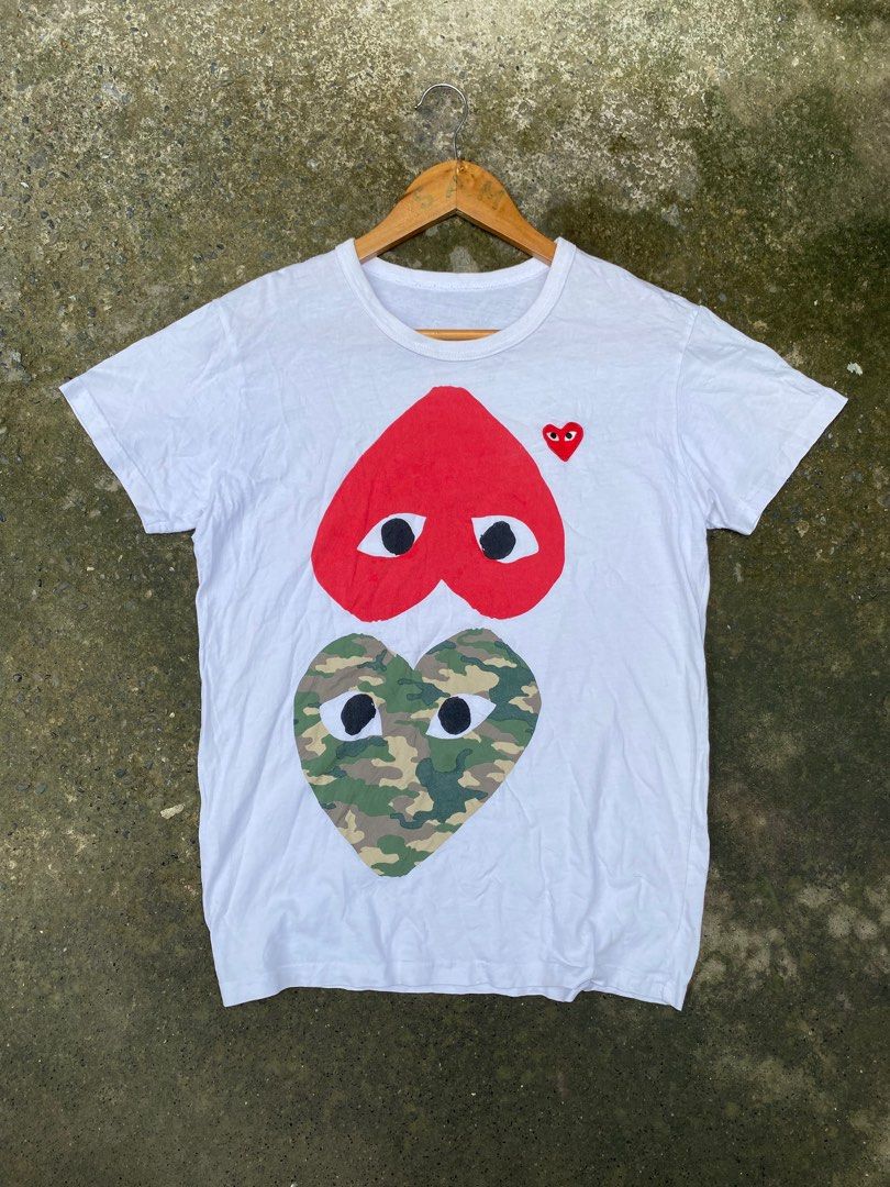 Off ❌Comme des Garcons Play Heart T-shirt (Category: Shirts) located in Santo Tomas. Submitted by zahzahfindsph (Listing ID 1406058585, Image 1). Description: - Comme des Garcons Play t-shirt - Features the iconic heart design - Two heart designs: red and camouflage - Signature eye logo - Crew neck - Short sleeves - Lightweight fabric - Perfect for casual wear.