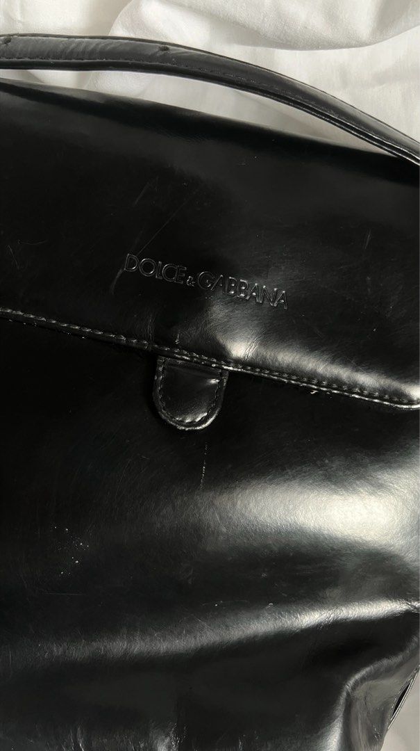 Dolce & Gabbana Black Shoulder Bag (Category: Luxury Bags & Wallets) located in Quezon City. Submitted by hollyyybac25473 (Listing ID 1405988983, Image 2). Description: - Dolce & Gabbana shoulder bag - Black color - Flap closure with magnetic snap - Interior zippered pocket with Dolce & Gabbana label - Long strap for shoulder or crossbody wear - Gold-toned hardware Well used. Rusty metal buckles (can still be removed). Actual photos posted, pleas