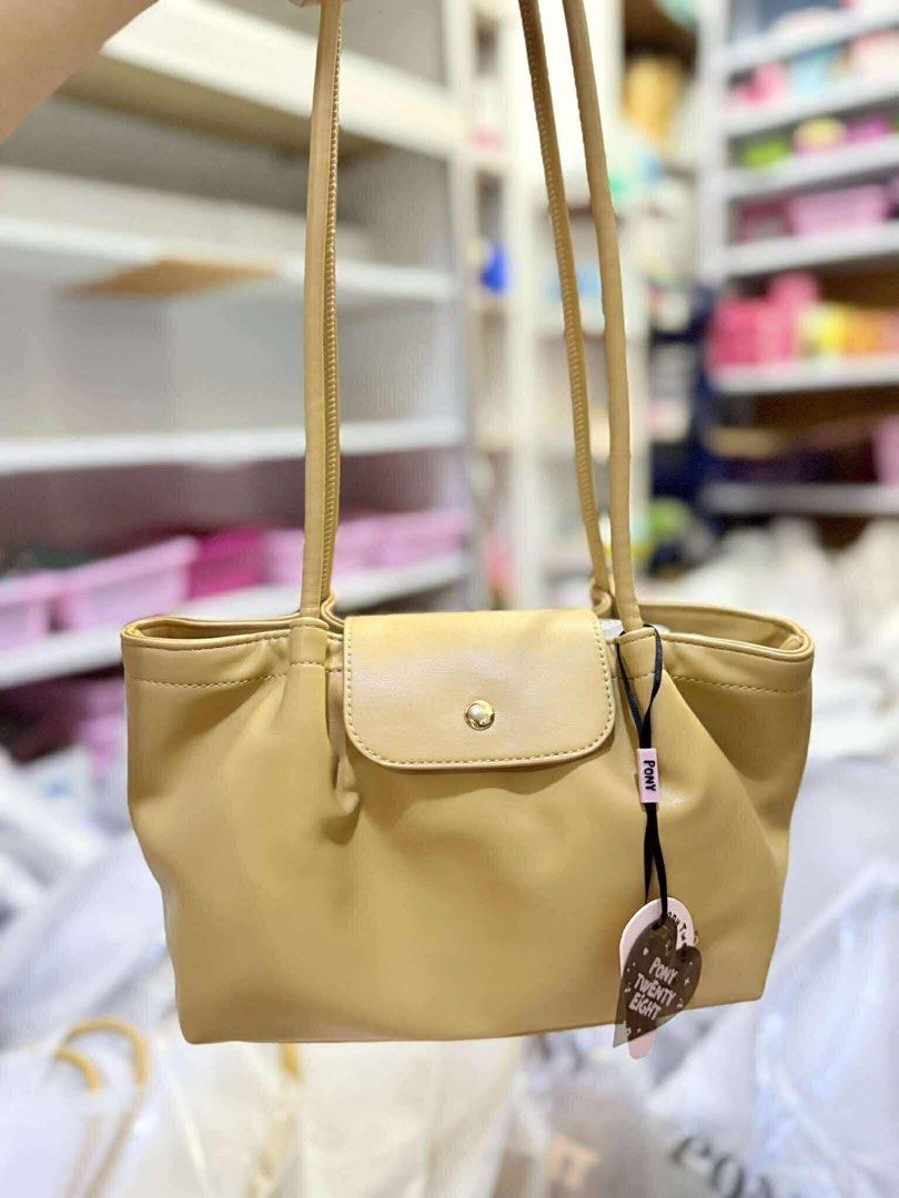 Liya Pony Twenty Eight Shoulder Bag (Category: Luxury Bags & Wallets) located in Paranaque City. Submitted by jessamm (Listing ID 1406039464, Image 2). Description: - Pony Twenty Eight shoulder bag - Available in pink and butter yellow - Flap closure with gold-tone button - Includes a small charm - Simple, elegant design - Long straps for comfortable shoulder wear - Perfect for everyday use.