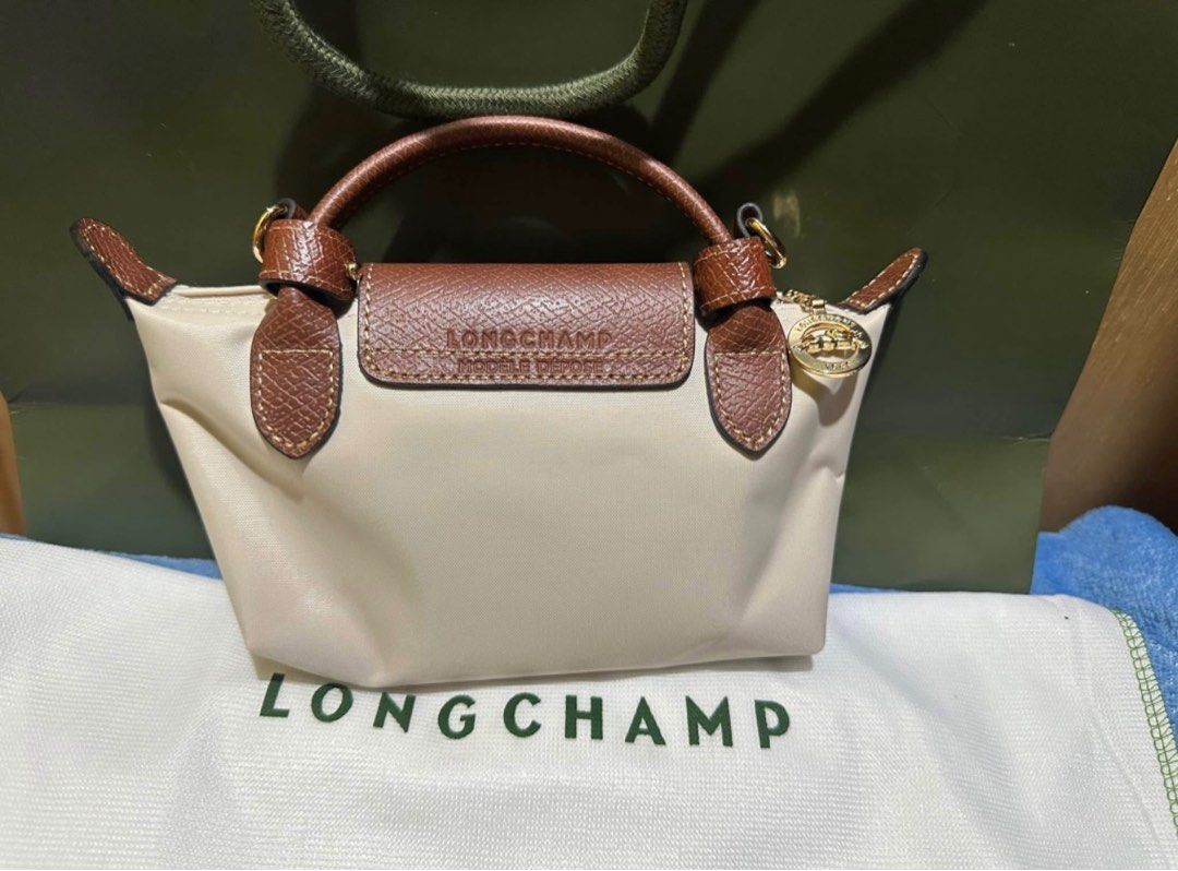 Longchamp Le Pliage Mini Bag (Category: Luxury Bags & Wallets) located in Manila. Submitted by n_a_c (Listing ID 1405963685, Image 2). Description: - Longchamp Le Pliage Mini Bag - Color: Paper with brown leather accents - Detachable shoulder strap included - Features top handle - Flap closure with Longchamp logo - Gold-tone zipper and hardware - Includes Longchamp tag.