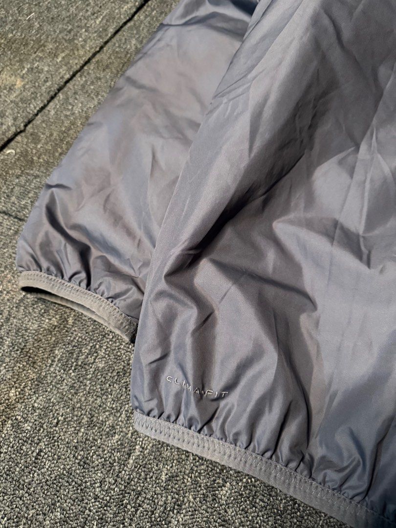 Nike ACG Puffer Windbreaker (Category: Coats, Jackets and Outerwear) located in San Marcelino. Submitted by SoloMain (Listing ID 1406055118, Image 3). Description: Nike ACG puffer windbreaker features a gray exterior with a red interior. It has a zip closure, a pocket on the chest, and the ACG logo on the sleeve. The jacket is labeled as Clima-Fit. The width is 25.5 inches and the length is 27.5 inches..
