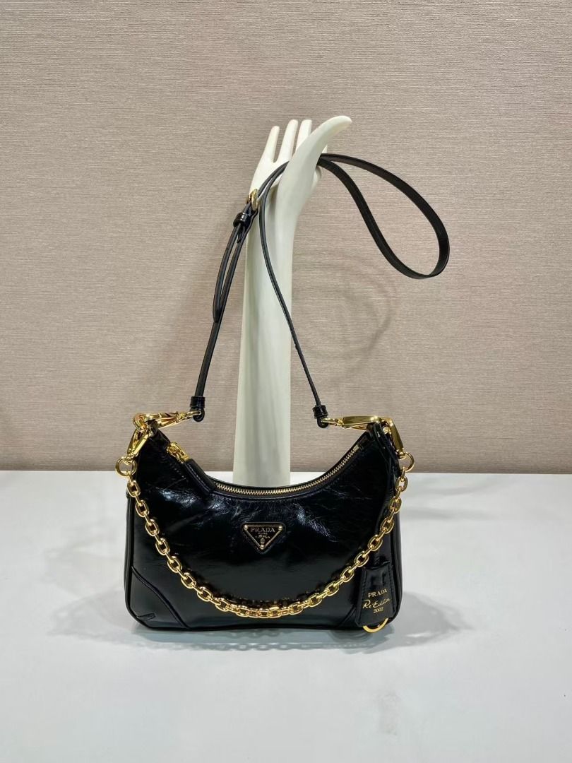 Prada Re-Edition 2005 Hobo Bag (Category: Luxury Bags & Wallets) located in Paranaque City. Submitted by kohomirica92485 (Listing ID 1405985204, Image 1). Description: - Prada Re-Edition 2005 Hobo bag - Color: Black - Hardware: Gold-tone - Features: Chain strap, detachable and adjustable shoulder strap, Prada tag - Closure: Zip - Details: Prada logo on front.