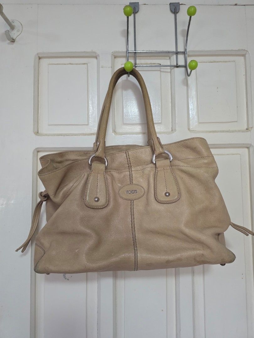 Tod's Beige Leather Tote Bag (Category: Luxury Bags & Wallets) located in Taguig. Submitted by bree_nice (Listing ID 1405946329, Image 1). Description: - Authentic Tod's tote bag - Beige leather - Double handles - 2 Interior zip pockets - Visible wear and tear (marks on exterior and lining), with pen marks inside, no holes, rips or tears - Tod's logo visible - Medium size.