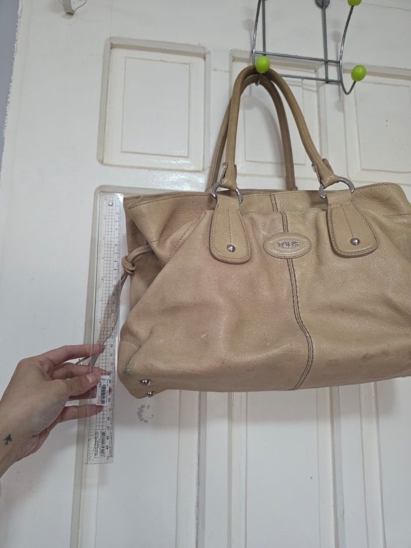 Tod's Beige Leather Tote Bag (Category: Luxury Bags & Wallets) located in Taguig. Submitted by bree_nice (Listing ID 1405946329, Image 3). Description: - Authentic Tod's tote bag - Beige leather - Double handles - 2 Interior zip pockets - Visible wear and tear (marks on exterior and lining), with pen marks inside, no holes, rips or tears - Tod's logo visible - Medium size.
