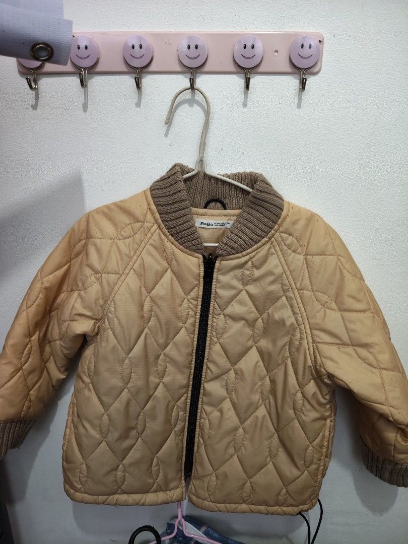 Unisex BeBe Quilted Jacket natanggal lang tag (Category: Babies & Kids Fashion) located in Victoria. Submitted by reignf027 (Listing ID 1405926811, Image 1). Description: - Brand: BeBe - Style: Kids' quilted jacket - Color: Light tan - Features: Ribbed collar and cuffs, full-length zipper closure.