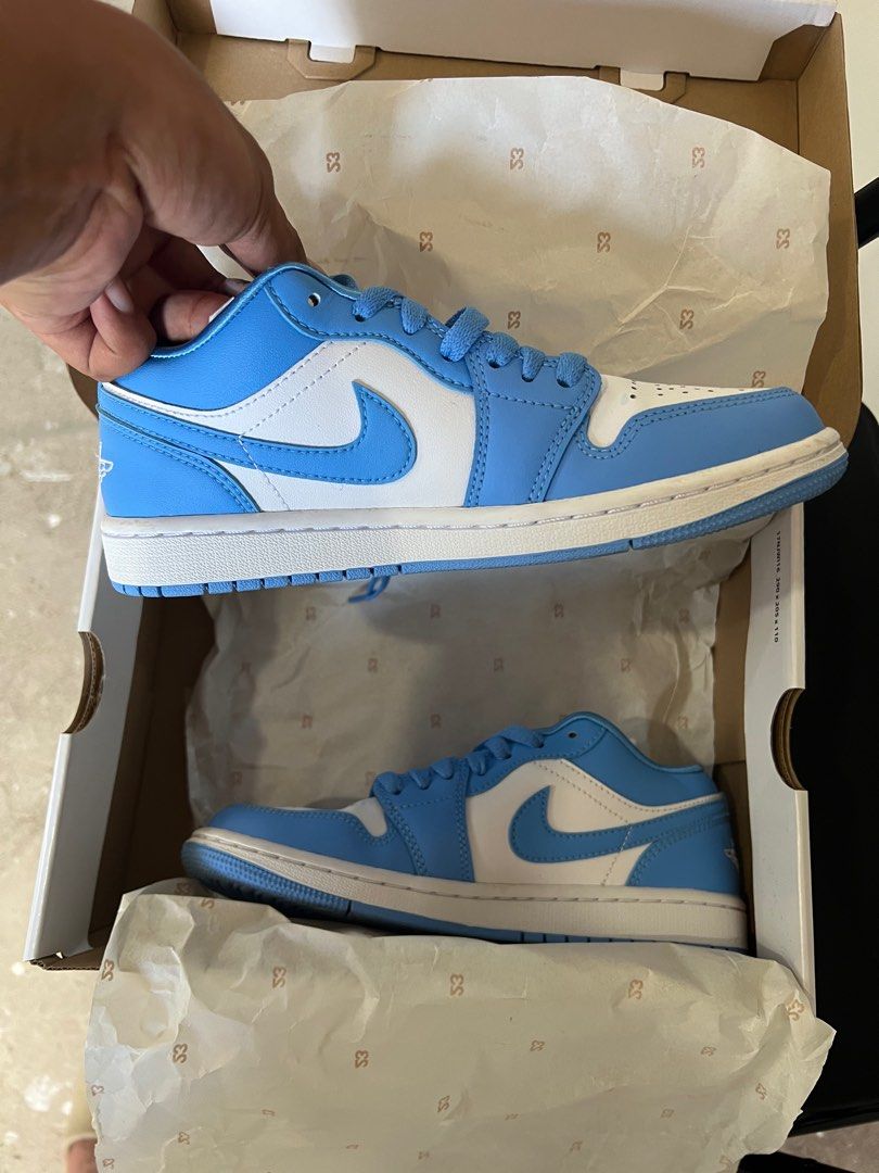 Air Jordan 1 Low UNC (Category: Sneakers) located in Pinamalayan. Submitted by initialthriftstore (Listing ID 1406227269, Image 2). Description: - Air Jordan 1 Low in UNC colorway - Light blue and white color scheme - Unworn condition - Includes original box - Air Jordan logo on heel - Size tag visible inside.