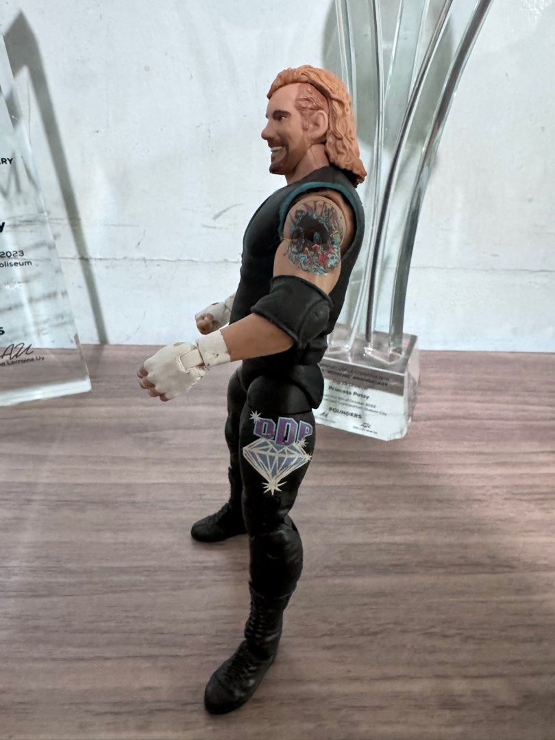 DDP Diamond Dallas Page Action Figure (Category: Action & Battle Toys) located in Quezon City. Submitted by princesspatsy100 (Listing ID 1406232616, Image 2). Description: - Diamond Dallas Page (DDP) action figure. - Features DDP in black vest and pants. - Detailed tattoos on arms. - Includes DDP logo on the back. - Collectible item for wrestling fans. - Posed in a standing position..