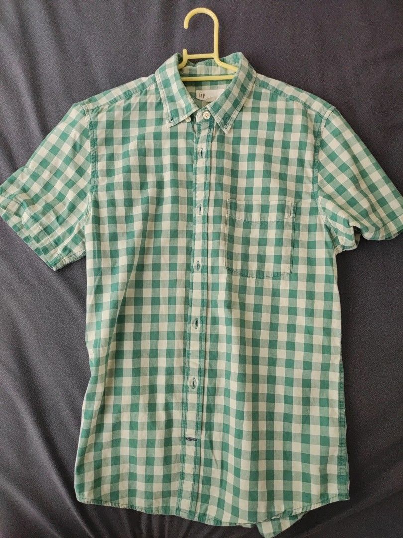 Gap button down (Category: Tshirts & Polo Shirts) located in Singapore. Submitted by timothy2006 (Listing ID 1406187702, Image 1). Description: This short-sleeved shirt features a classic green gingham pattern. It has a button-down front and a collar. The shirt appears to be in good condition.Perfect for casual wear..