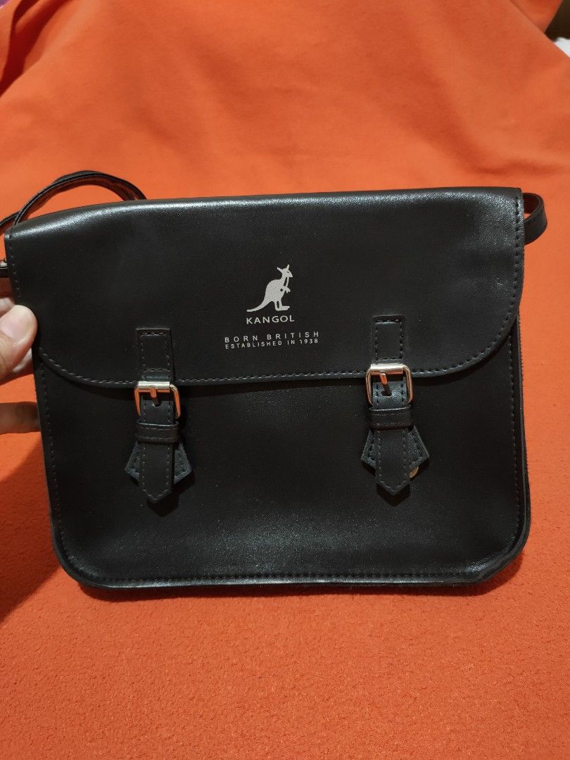 Kangol Shoulder Bag (Category: Shoulder Bags) located in Quezon City. Submitted by jhaneth21 (Listing ID 1406148338, Image 3). Description: - Black Kangol shoulder bag - Flap closure with buckle details - Features the iconic Kangol logo - Adjustable shoulder strap for a comfortable fit - Includes an interior pocket for organization Size: 9" x 7.5" x 1.5".