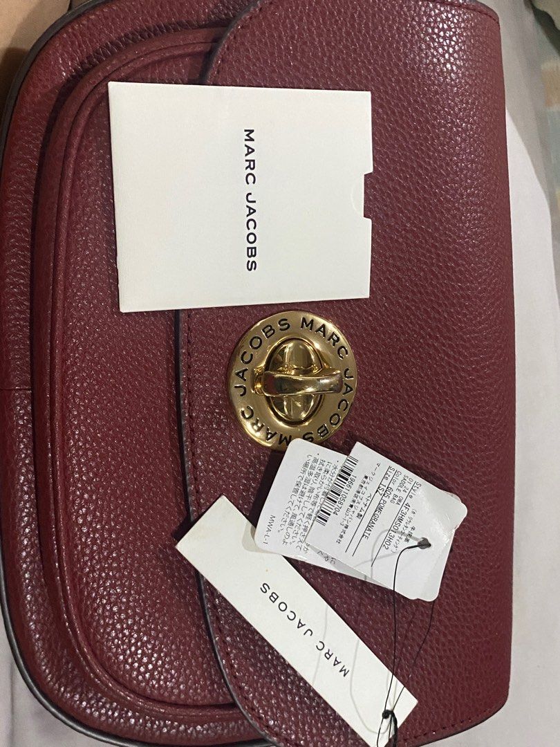 Marc Jacobs Signet Turnlock Saddle Bag (Category: Luxury Bags & Wallets) located in Cainta. Submitted by ahyish (Listing ID 1406232410, Image 3). Description: - Authentic Marc Jacobs Saddle bag - Burgundy leather exterior - Gold-tone logo clasp - Detachable striped strap with Marc Jacobs logo (some marks present) - Burgundy interior - Interior pocket - Comes with original tags.