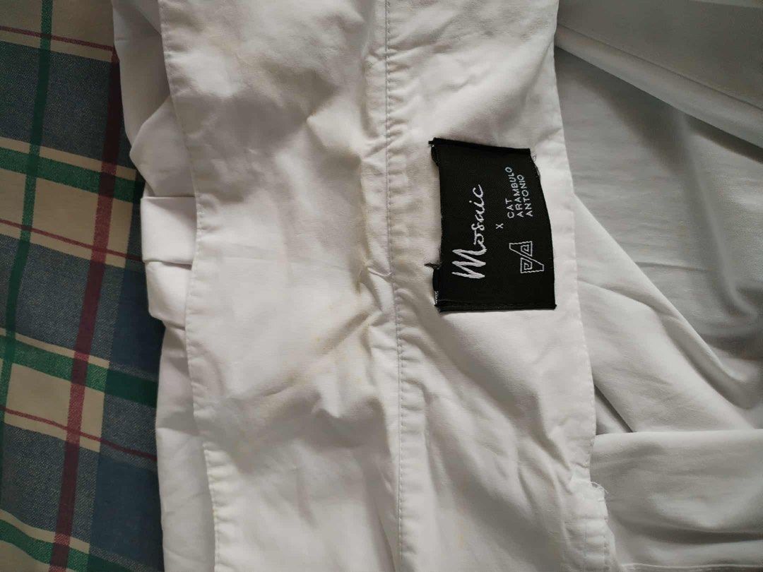 Mosaic White Long Sleeve Shirt (Category: Blouses) located in Pasig City. Submitted by jacq0301 (Listing ID 1406127779, Image 3). Description: - Mosaic white long sleeve shirt - Classic collar and button-down front - Longer length - Pleated back detail - Visible stains on front and collar - Roll-up sleeves - Lightweight fabric.