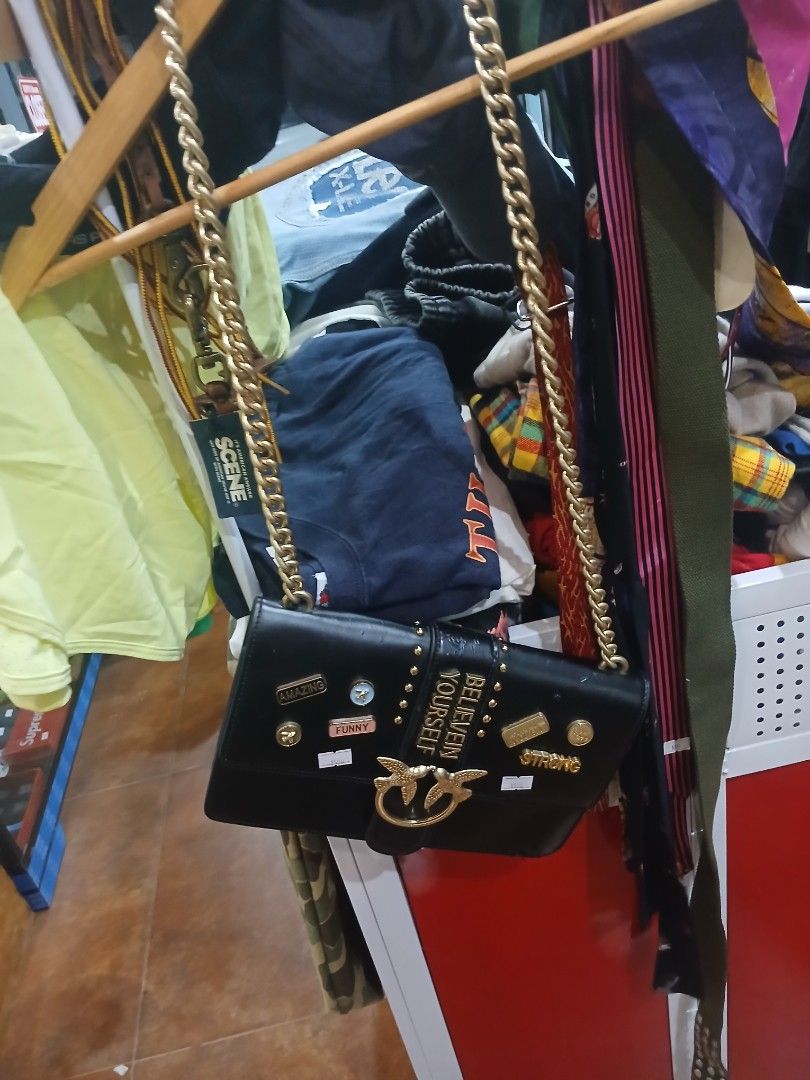 Pinko Black Handbag with Embellishments (Category: Luxury Bags & Wallets) located in Cebu City. Submitted by perfectzero (Listing ID 1406205406, Image 2). Description: Black handbag with gold-colored chain strap. Features decorative embellishments including the words "STRONG" and "BELIEVE IN YOURSELF". The bag has a flap closure with a bird-shaped clasp..
