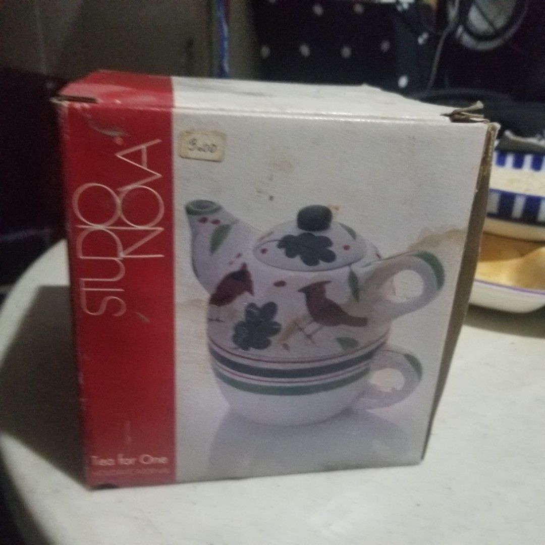Studio Nova Tea for One Teapot (Category: Coffee & Tea Tableware) located in Paranaque City. Submitted by showboat (Listing ID 1406108913, Image 1). Description: - Studio Nova Tea for One set - Features a white teapot with floral and bird designs - Includes a matching cup - Teapot has a green handle - Comes in its original box.