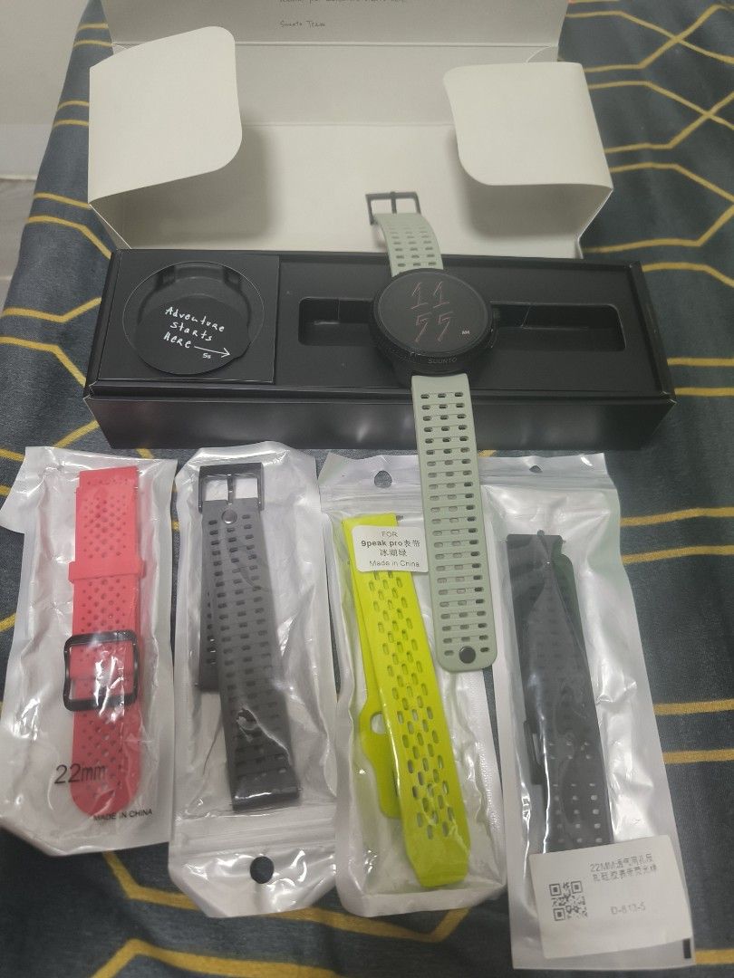 Suunto Race All Black Smartwatch (Category: Men's Watches) located in Cavite. Submitted by bowthrustalexey (Listing ID 1406128963, Image 3). Description: Suunto Race All Black smartwatch with multiple straps. Includes the original box, charging cable, and additional straps in red, black, and yellow. The watch features a round display and a black bezel. The box indicates the watch is designed in Finland and made in China. The watch has a green str