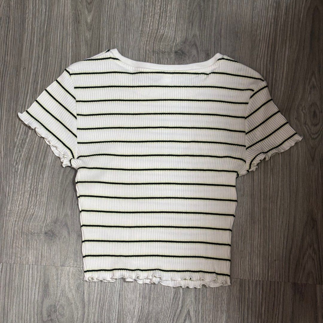Uniqlo Striped Ruffle Ribbed Top (S) (Category: Shirts) located in Valenzuela. Submitted by choppersells (Listing ID 1406204681, Image 2). Description: 🖤 Uniqlo Striped Ruffle Ribbed Top (S) Features a white ribbed fabric with horizontal black and subtle neon yellow stripes. It has a crew neck, short sleeves, and cute lettuce-edge ruffle trim on the sleeves and hemline. 📏 Size: Small 🛍️ Bought in Hong Kong ✨ Condition: Excellent condition. 🚚 