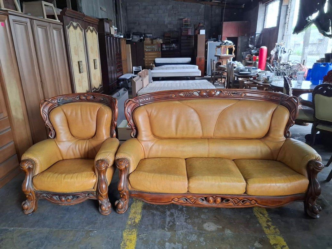 Vintage Leather Sofa and Armchair Set (Category: Sofas) located in Angeles City. Submitted by maryannmar33098 (Listing ID 1406145281, Image 2). Description: Elegant vintage sofa set featuring a three-seater sofa and a matching armchair. Both pieces are upholstered in a warm, textured leather. The frames are crafted from dark wood with intricate carvings. This set would be a great addition to any living room, offering both comfort and classic styl