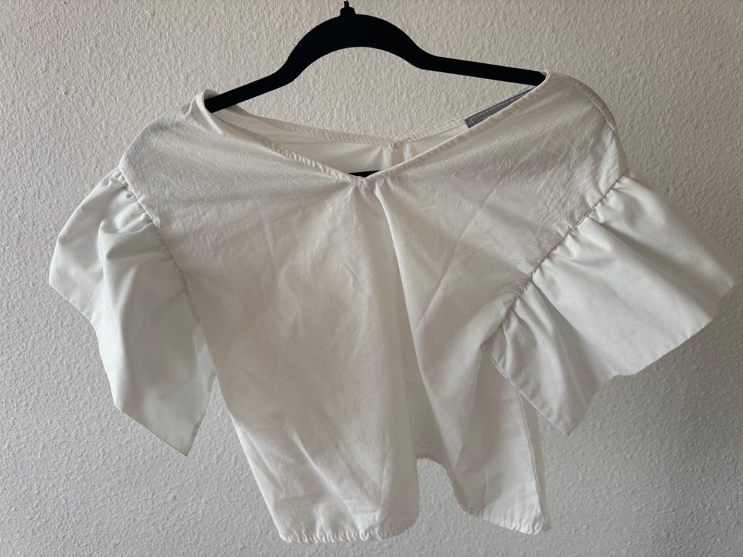 White Ruffle Sleeve Top (Category: Blouses) located in San Juan City. Submitted by baudeclutter (Listing ID 1406226558, Image 1). Description: - White V-neck top - Short sleeves with ruffle detail - Lightweight fabric - Relaxed fit - Versatile for different outfits - Solid white color.