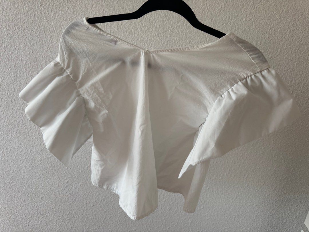 White Ruffle Sleeve Top (Category: Blouses) located in San Juan City. Submitted by baudeclutter (Listing ID 1406226558, Image 2). Description: - White V-neck top - Short sleeves with ruffle detail - Lightweight fabric - Relaxed fit - Versatile for different outfits - Solid white color.