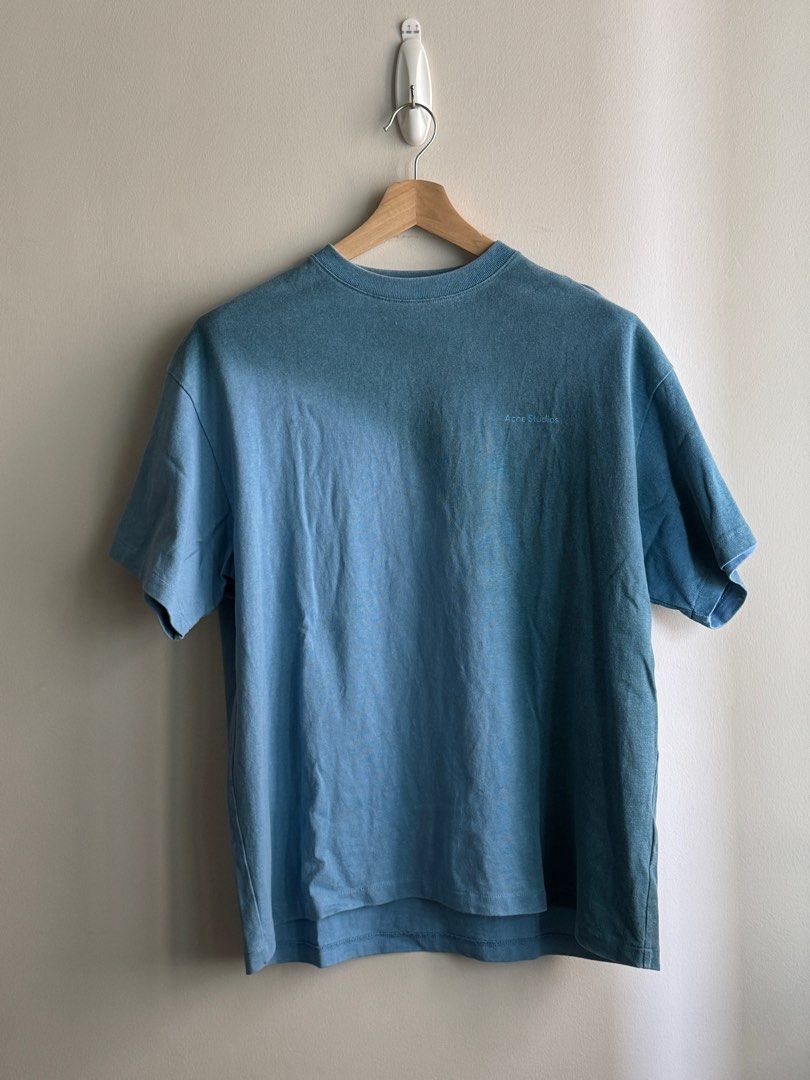 Acne Studios Oversized Blue Cotton T-shirt (Category: Tshirts & Polo Shirts ) located in Pasig City. Submitted by heattsupply (Listing ID 1406295983, Image 1). Description: Acne Studios T-shirt is made of 100% cotton. It features a light blue color and a crew neck. The Acne Studios logo is visible on the front and inside the collar. The tag indicates it was made in Portugal. Oversized fit Measurements: 24W x 29.