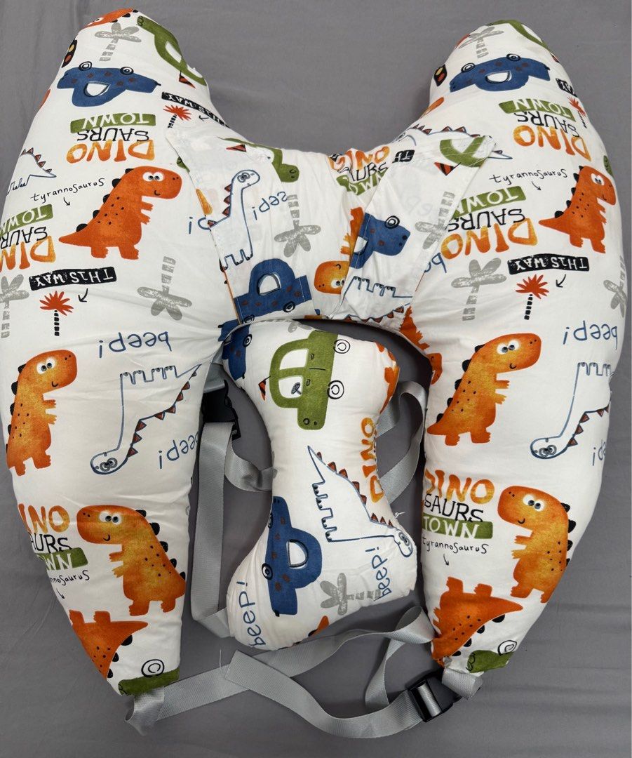 Dinosaur Print Pillow Car (Category: Car Seats) located in Pasay City. Submitted by szepter (Listing ID 1406321027, Image 2). Description: - Fun dinosaur and car print design - Curved design for comfortable breastfeeding support - Includes a smaller, detachable pillow for added support - Features straps for secure positioning - Soft fabric and colorful design.