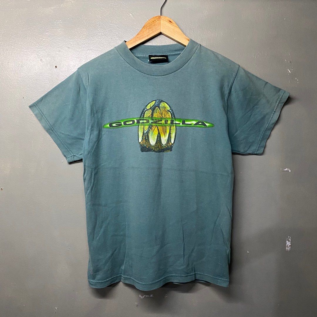 Godzilla Movie T-Shirt (Category: Tshirts & Polo Shirts ) located in Cagayan de Oro. Submitted by sumamestreethub (Listing ID 1406423601, Image 1). Description: - Vintage Godzilla t-shirt - From 1998 - Features Godzilla logo and monster design - Graphic on front and back - Teal fabric - Perfect for Godzilla fans! W18.5 L25.
