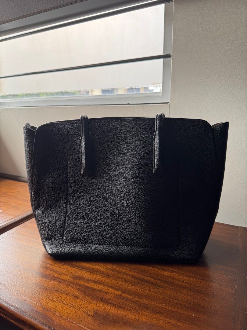 Kate Spade Black Leather Tote Bag (Category: Tote Bags) located in Lipa City. Submitted by trixpelliarmus (Listing ID 1406312307, Image 2). Description: - Kate Spade black leather tote bag - Spacious main compartment - Interior zippered pocket and slip pocket - Double top handles - Protective metal feet - Textured leather exterior - Light beige fabric lining.