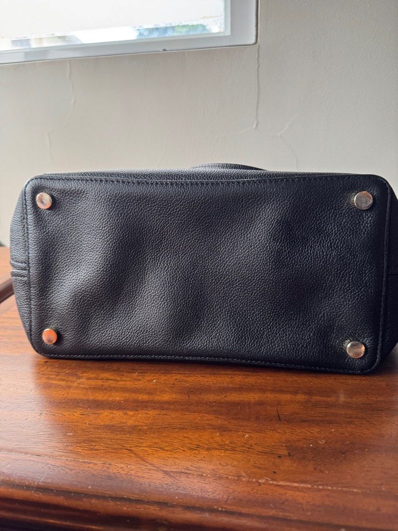 Kate Spade Black Leather Tote Bag (Category: Tote Bags) located in Lipa City. Submitted by trixpelliarmus (Listing ID 1406312307, Image 3). Description: - Kate Spade black leather tote bag - Spacious main compartment - Interior zippered pocket and slip pocket - Double top handles - Protective metal feet - Textured leather exterior - Light beige fabric lining.