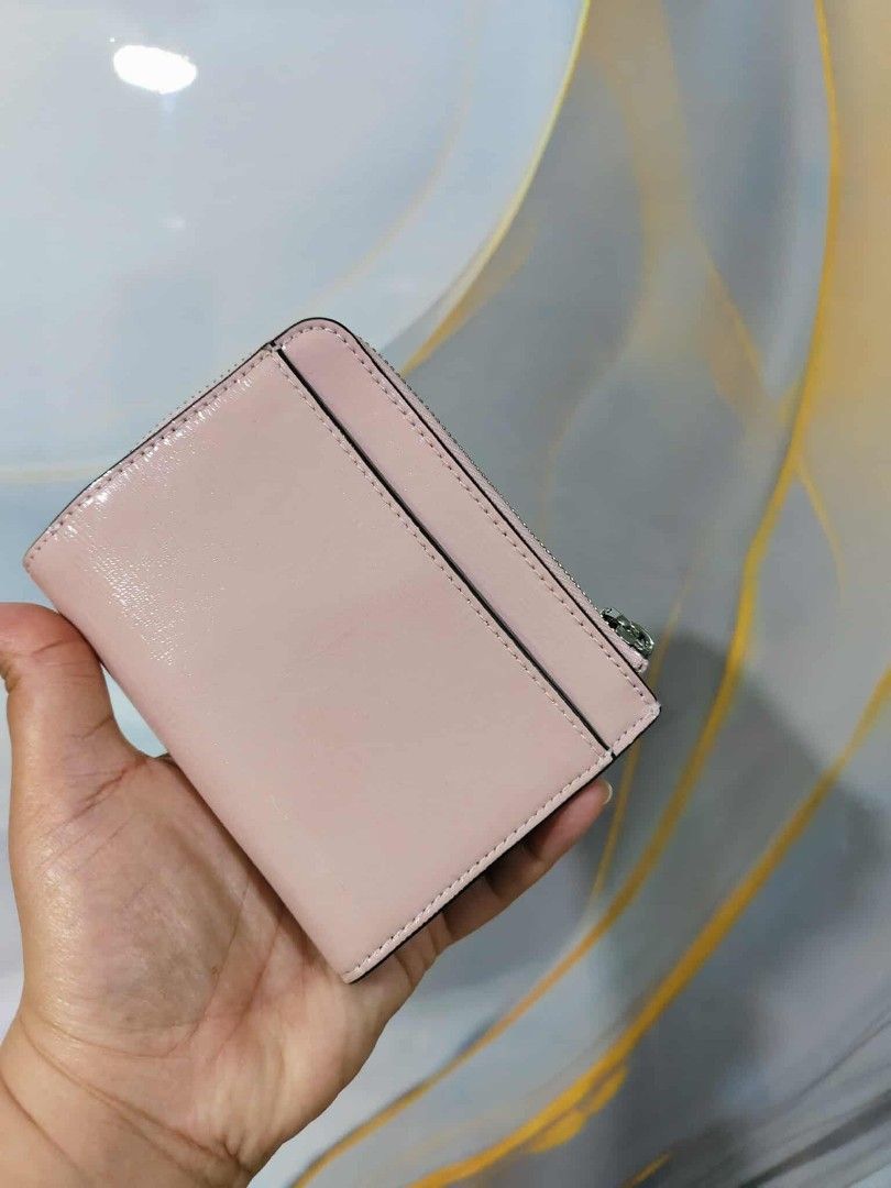 Kate Spade New York Zip Around Wallet (Category: Wallets & Card holders) located in Manila. Submitted by oliviavaleria (Listing ID 1406385929, Image 2). Description: - Kate Spade wallet - Zip-around closure - Light pink exterior - Multiple card slots - Coin compartment - Deep red interior lining - Silver zipper - Kate Spade logo on front.