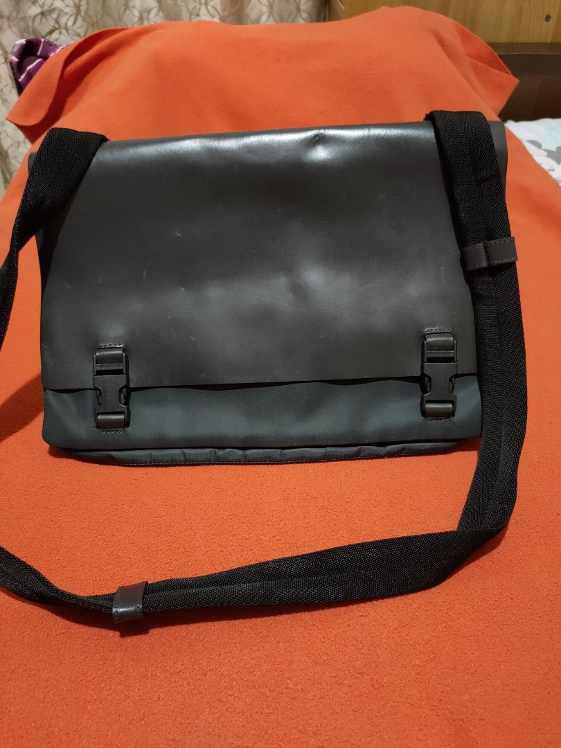 Minelli Messenger Bag - Made in Italy (Category: Sling Bags) located in Quezon City. Submitted by jhaneth21 (Listing ID 1406383311, Image 1). Description: Stylish messenger bag by Minelli, made in Italy. Features a sleek, dark color with a flap closure secured by two buckles. The bag has a wide, adjustable shoulder strap for comfortable carrying. Inside, it has multiple compartments for organized storage. The interior includes a branded label. Pe