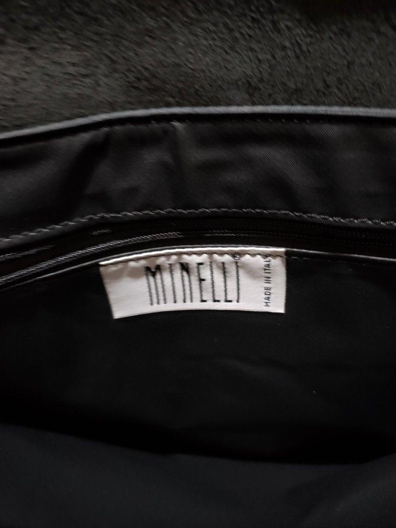 Minelli Messenger Bag - Made in Italy (Category: Sling Bags) located in Quezon City. Submitted by jhaneth21 (Listing ID 1406383311, Image 2). Description: Stylish messenger bag by Minelli, made in Italy. Features a sleek, dark color with a flap closure secured by two buckles. The bag has a wide, adjustable shoulder strap for comfortable carrying. Inside, it has multiple compartments for organized storage. The interior includes a branded label. Pe