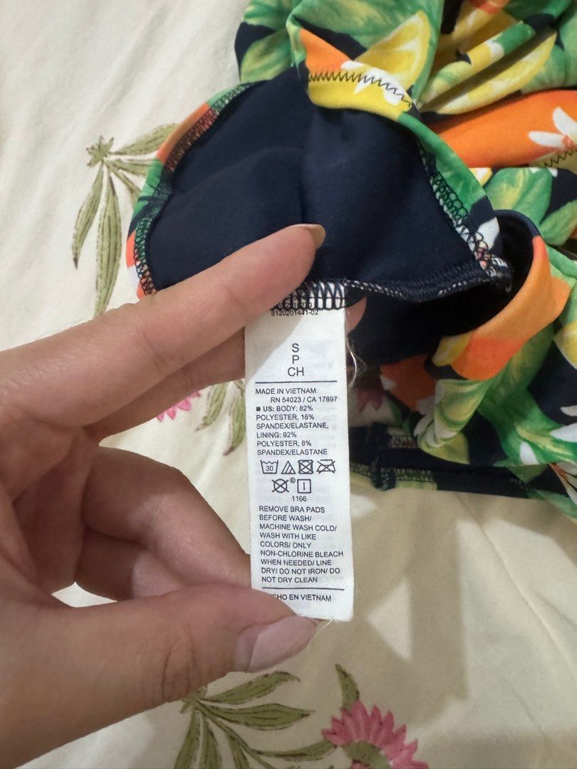 Old Navy Fruit Print Swimsuit - Size S (Category: Bikinis & Swimsuits) located in Pasig City. Submitted by sud38405 (Listing ID 1406393788, Image 3). Description: Old Navy swimsuit features a vibrant fruit print. It has a navy blue lining and a cut-out back design. The size is Small (S). The fabric composition is 82% body, 18% spandex/elastane, and the lining is 100% polyester. Made in Vietnam. Not used, tag removed.