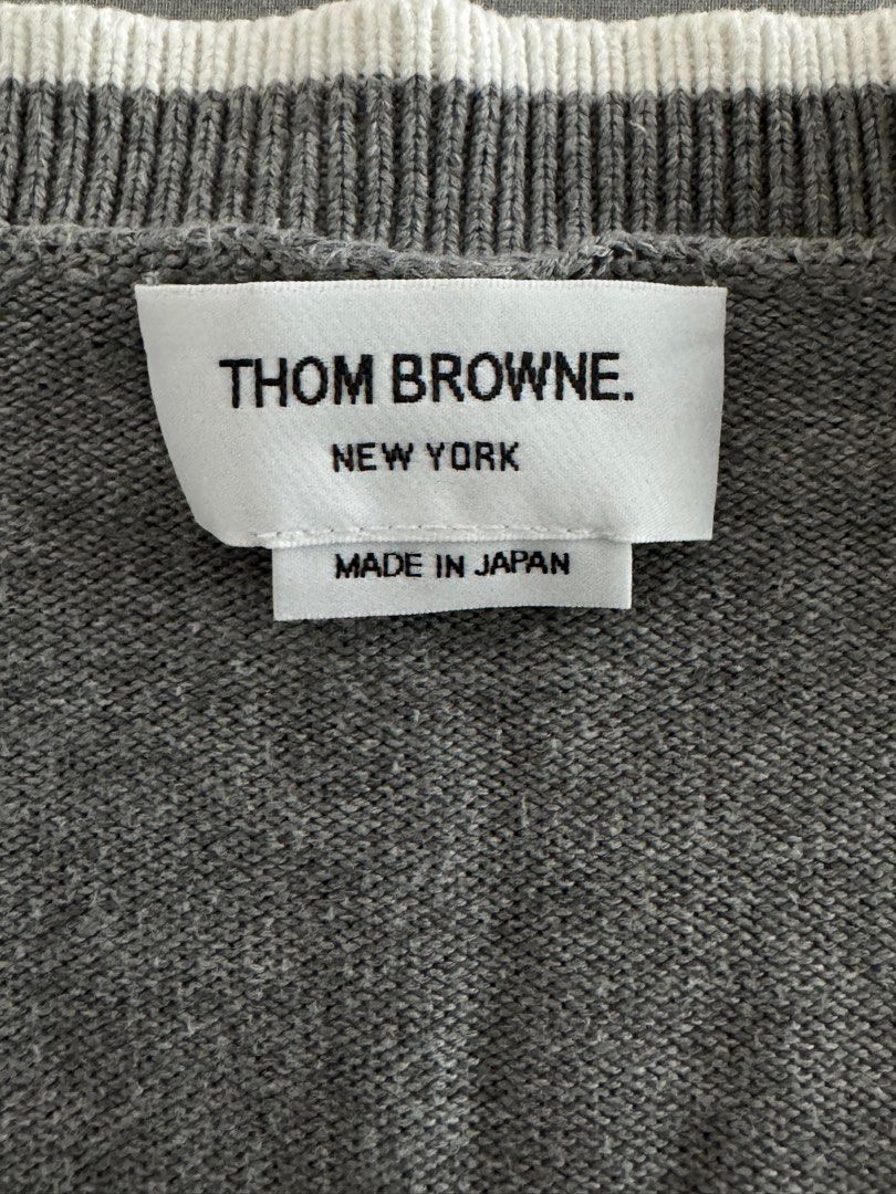 Thom Browne Grey Cardigan (Category: Luxury Apparel) located in Pasig City. Submitted by heattsupply (Listing ID 1406293392, Image 2). Description: Thom Browne grey cardigan. Features white trim, four-bar detail, V-neck, button closure, and front pockets. Made in Japan. Size 1. 100% cotton. Measurements: 21.75W x 27.5L.