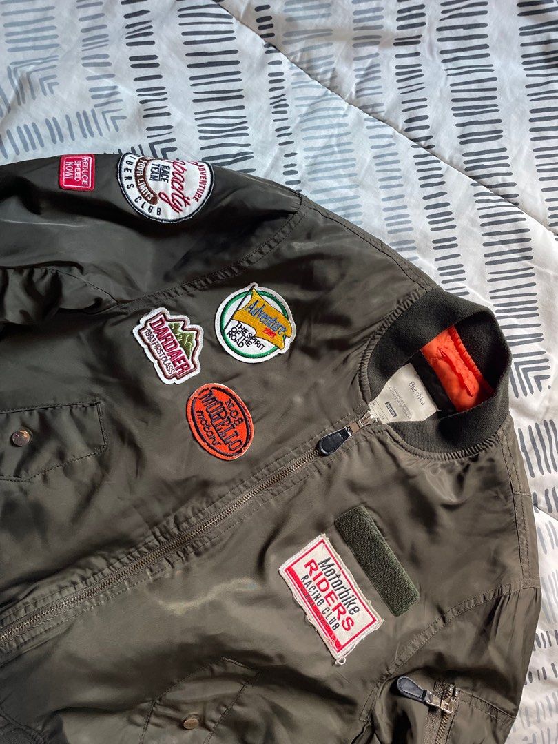 Bershka Bomber Jacket with Patches (Category: Coats, Jackets and Outerwear) located in Las Pinas. Submitted by bmtl_ (Listing ID 1406554671, Image 2). Description: Stylish Bershka bomber jacket in olive green. Features multiple patches, a zip closure, and ribbed cuffs and hem. The jacket has an orange lining. Size M. Perfect for adding a touch of edge to any outfit. RFS: Decluttering Negotiable.
