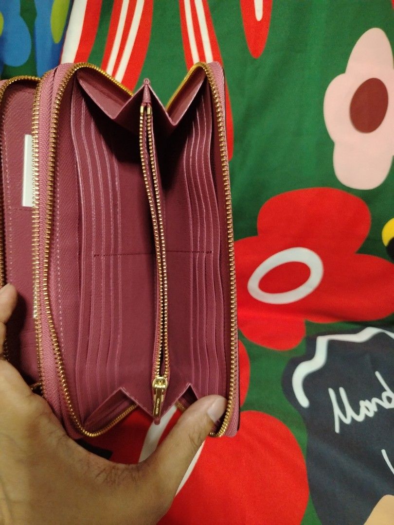 Coach Wristlet Wallet (Category: Luxury Bags & Wallets) located in Las Pinas. Submitted by ecarg2072 (Listing ID 1406614783, Image 2). Description: - Authentic Coach wristlet wallet - Solid pink color with gold-tone hardware - Zip-around closure - Top handle - Interior: Multiple card slots and compartments - Includes a zip pocket and a slip pocket - Comes with Coach cards.