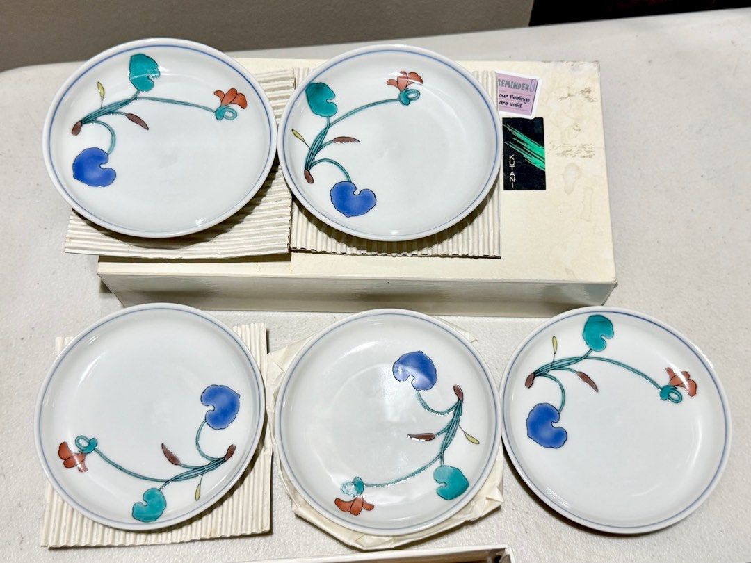 Kutani Japanese Ceramic Plates Set (Category: Dinnerware & Cutlery) located in Rizal. Submitted by caintarizal2024 (Listing ID 1406565019, Image 1). Description: This is a set of Kutani ware small porcelain plates, featuring a distinctive floral design in vibrant overglaze colors - Japanese ceramic plates - Floral design - White base with blue rim - Colorful floral pattern - Set includes multiple plates - In original packaging - Stamped on the bo