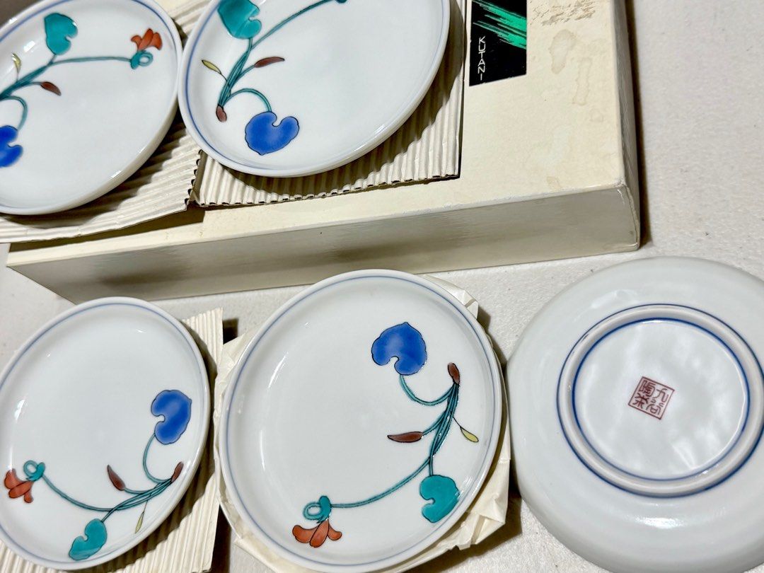 Kutani Japanese Ceramic Plates Set (Category: Dinnerware & Cutlery) located in Rizal. Submitted by caintarizal2024 (Listing ID 1406565019, Image 2). Description: This is a set of Kutani ware small porcelain plates, featuring a distinctive floral design in vibrant overglaze colors - Japanese ceramic plates - Floral design - White base with blue rim - Colorful floral pattern - Set includes multiple plates - In original packaging - Stamped on the bo